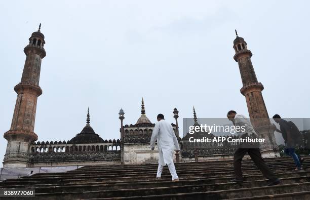 Indian men climb the stairs next to the mosque at the Bara Imambara, a colossal imambara complex in Lucknow, northern India, on August 25, 2017. /...