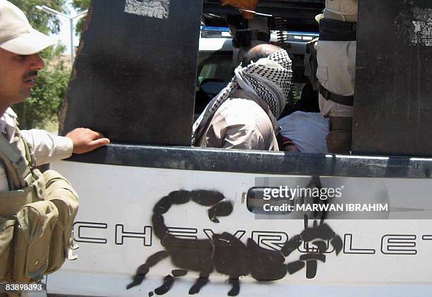 Men sit blind folded in the back of a vehicle after being arrested by the Iraqi soldiers from the Scorpion unit in Mosul, 370 kilometers north of the...