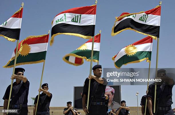 Newly graduated anti-riot police officers hold the Iraqi and Kurdish flags during a commencement ceremony in Sulaimaniyah, 330 kms north of Baghdad,...