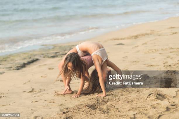 sisters playing in the sand together - dipping stock pictures, royalty-free photos & images