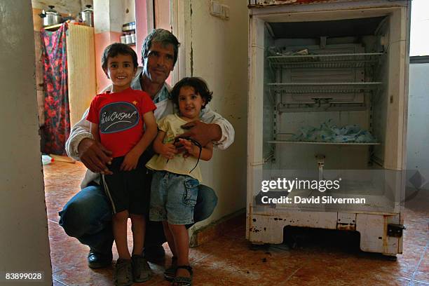 Palestinian beekeeper Muafak Faris Najem, who has been unemployed since a work injury a few years ago, poses proudly with two of his children Moeman...