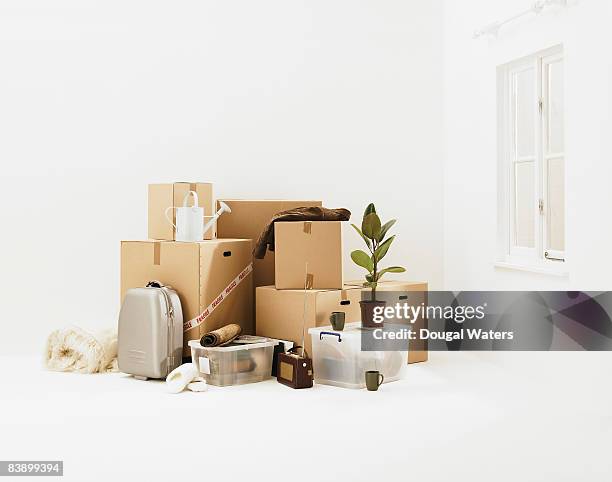 household belongings in white room. - moving box ストックフォトと画像