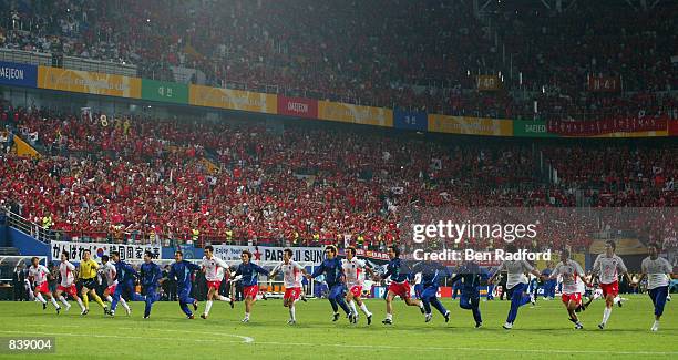 South Korea team run the length of the pitch to celebrate their 2-1 victory after the FIFA World Cup Finals 2002 Second Round match between South...