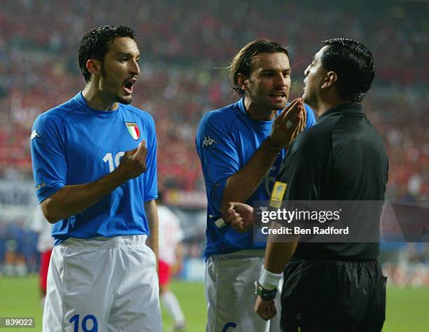 Gianluca Zambrotta and Cristiano Zanetti of Italy protest to referee Byron Moreno of Ecuador after he awarded a penalty to South Korea during the...