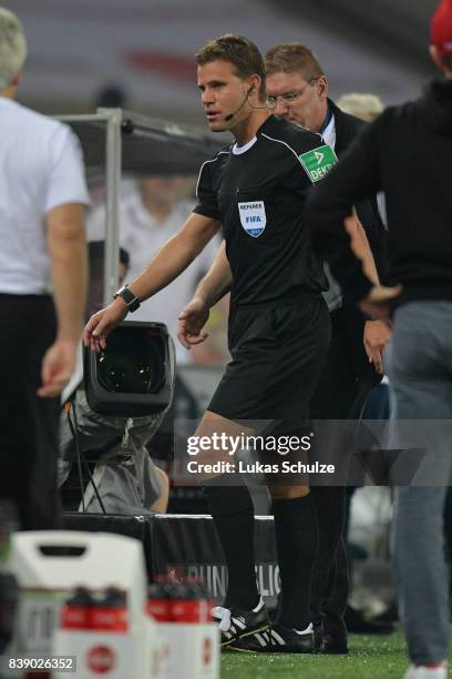 Referee Felix Brych leaves has to leave the match with an injury during the Bundesliga match between 1. FC Koeln and Hamburger SV at...