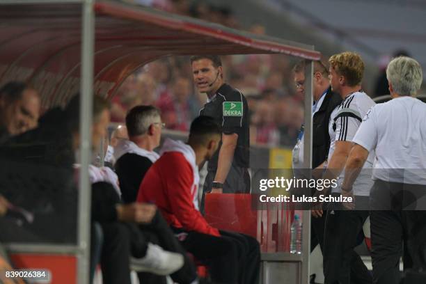 Referee Felix Brych leaves has to leave the match with an injury during the Bundesliga match between 1. FC Koeln and Hamburger SV at...