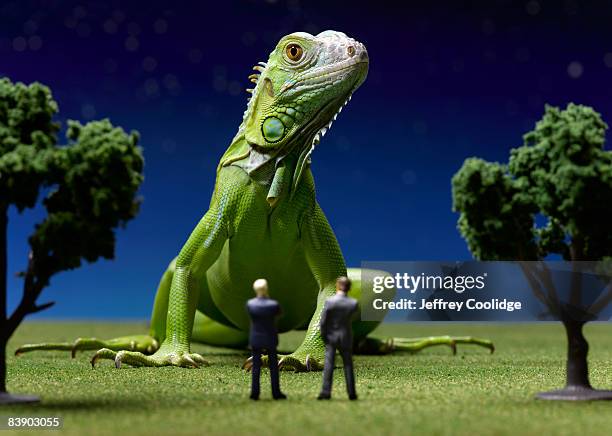 iguana confronting toy businessmen - think big stock pictures, royalty-free photos & images