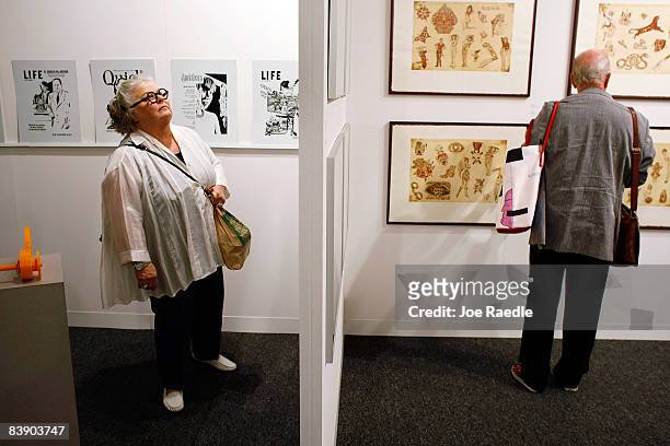 Karen Duncan and Robert Duncan look at art hanging on the walls of the Poligrafa Obra Grafica gallery as they attend Art Basel Miami Beach December...