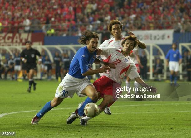 Francesco Totti of Italy falls under the weight of the challenge from Chong Gug Song of South Korea but it is seen as a dive and he receives a red...