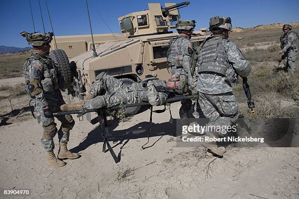 Army soldiers from the 4th Brigade Combat Team carry a stretcher with a simulated wounded soldier to a helicopter medevac position during a 5-day war...