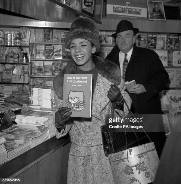 Last night's upset apparently forgotten, singer Shirley Bassey is evidently pleased with her choice of literature at the London Airport bookstall....