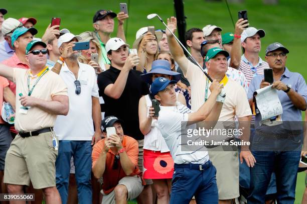 Jordan Spieth of the United States plays a shot on the 12th hole as fans take photographs with their cellphones during round two of The Northern...