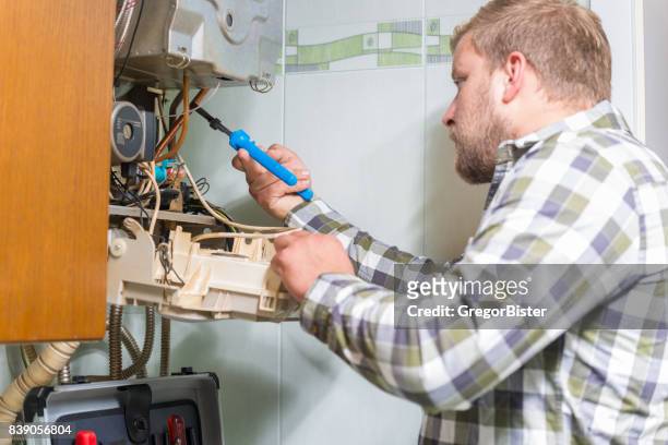 technician repairing gas furnace - home furnace stock pictures, royalty-free photos & images