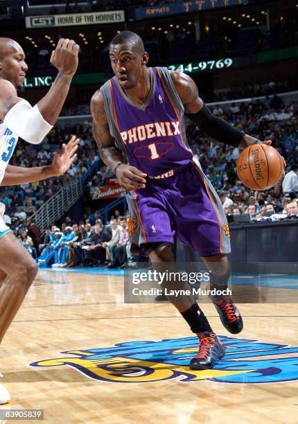 Amare Stoudemire of the Phoenix Suns drives against David West of the New Orleans Hornets at the New Orleans Arena December 3, 2008 in New Orleans,...