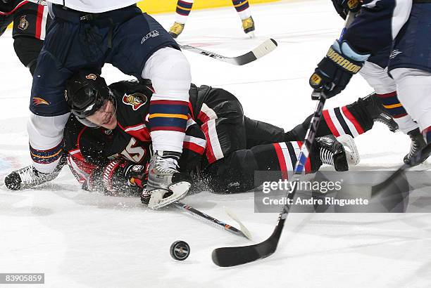 Anton Volchenkov of the Ottawa Senators gives a second effort and reaches for a loose puck while down on the ice against the Atlanta Thrashers at...