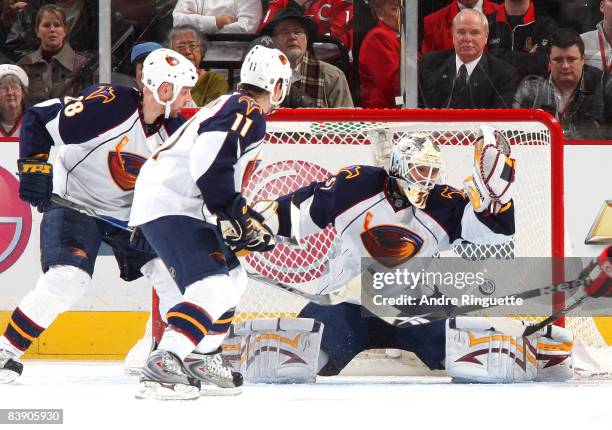 Ondrej Pavelec of the Atlanta Thrashers makes a save against the Ottawa Senators as Eric Perrin and Niclas Havelid of the Atlanta Thrashers support...