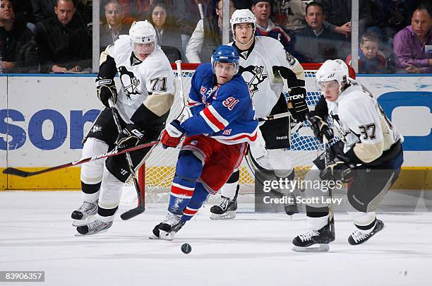 Markus Naslund of the New York Rangers skates for the puck against Evgeni Malkin and Sidney Crosby of the Pittsburgh Penguins on December 3, 2008 at...