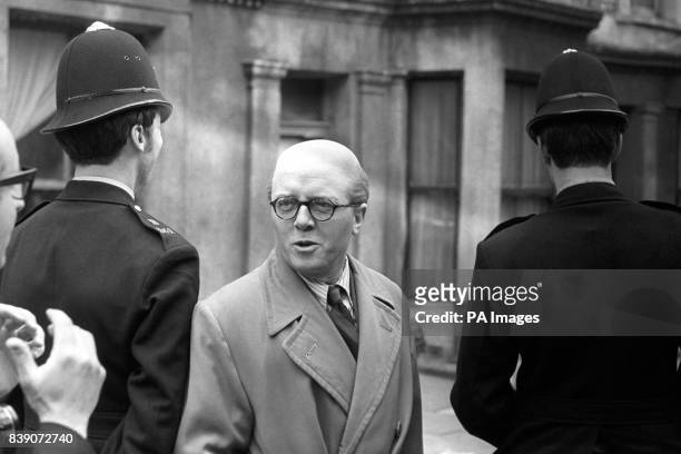 Actor Richard Attenborough, with a couple of policemen, visiting the former No. 10 Rillington Place, Notting Hill, the home of mass-murderer, John...