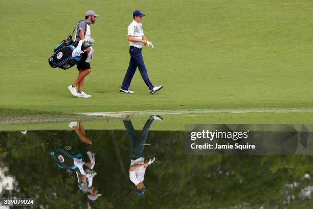 Jordan Spieth of the United States walks on the 15th hole with caddie Michael Greller during round two of The Northern Trust at Glen Oaks Club on...