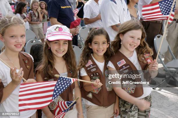 Girl Scouts holding flags on Veterans' Day at Police Department Plaza.