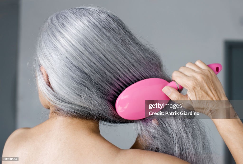 Mature woman with hair brush