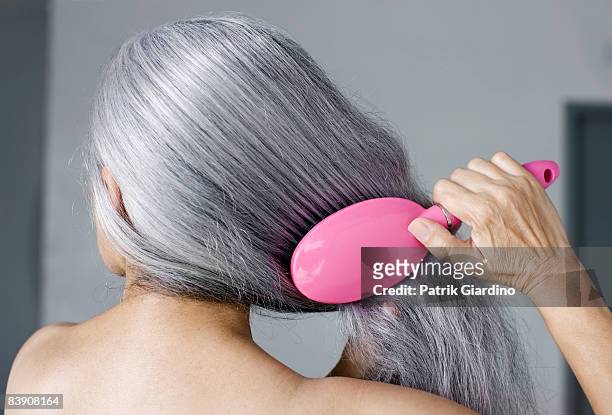 mature woman with hair brush - cheveux blancs photos et images de collection