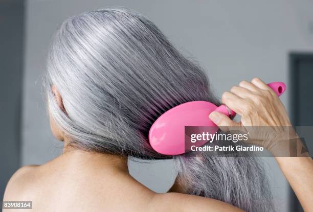 mature woman with hair brush - grey hair close up stock pictures, royalty-free photos & images