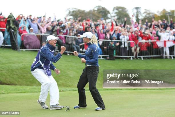 Europe's Suzann Pettersen celebrates with her caddy David Brooker after winning her singles match against USA's Michelle Wie during day three of the...