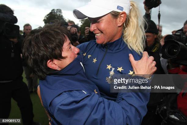 Europe's Suzann Pettersen celebrates with team captain Alison Nicholas after winning her singles match against USA's Michelle Wie during day three of...