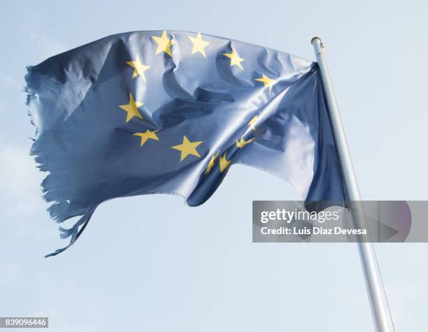 tattered european flag, still flying free and proud - frayed stock pictures, royalty-free photos & images