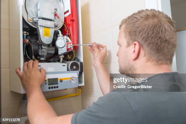 technician repairing gas furnace - boilers stock pictures, royalty-free photos & images