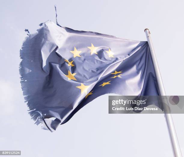 tattered european flag, still flying free and proud - frayed fabric stock pictures, royalty-free photos & images