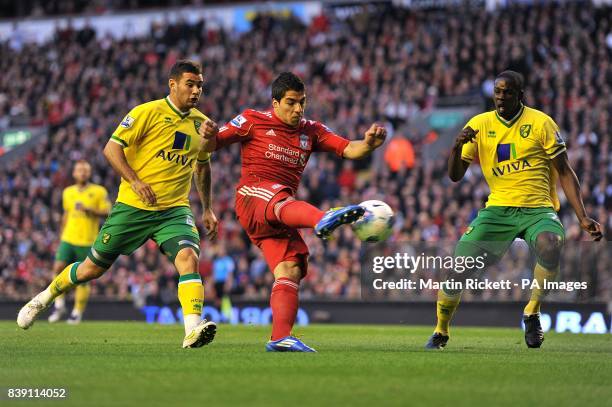Liverpool's Luis Suarez has a shot on goal despite the attentions of Norwich City's Leon Barnett and Bradley Johnson