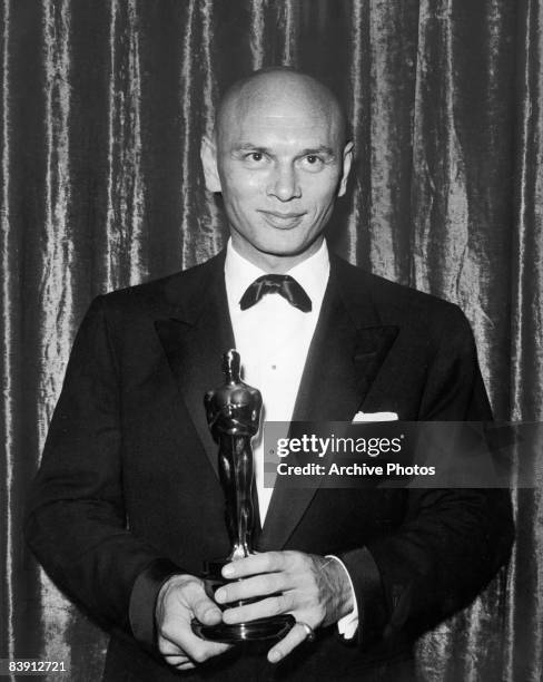 Russian-born actor Yul Brynner poses with his Best Actor Oscar for his role in the film 'The King and I', 27th March 1957.