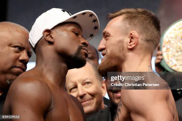 Boxer Floyd Mayweather Jr. And UFC lightweight champion Conor McGregor face off during their official weigh-in at T-Mobile Arena on August 25, 2017...