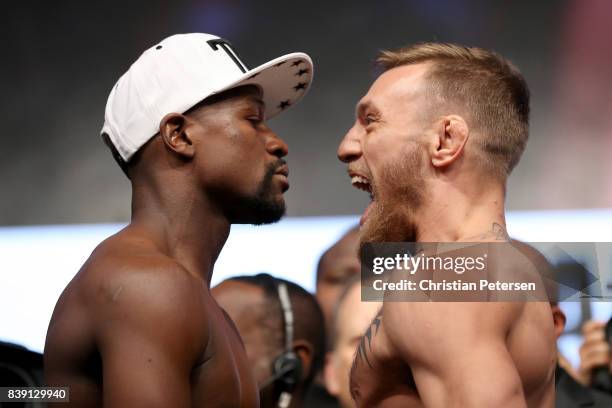 Boxer Floyd Mayweather Jr. And UFC lightweight champion Conor McGregor face off during their official weigh-in at T-Mobile Arena on August 25, 2017...