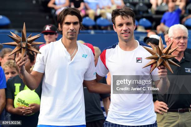 Julio Peralta of Chile and Horacio Zeballos of Argentina pose with their finalist's trophies after their finals match against Jean-Julien Rojer of...