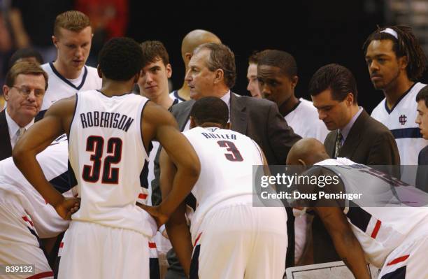 Head Coach Jim Calhoun of the University of Connecticut Huskies talks to his team in the huddle with assistant coaches Tom Moore and George Blaney in...