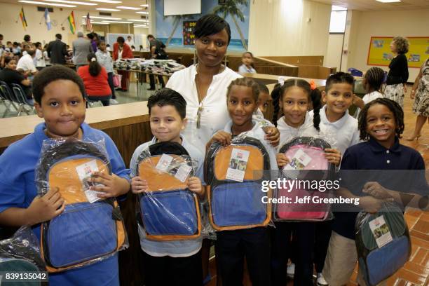 Students at Comstock Elementary School holding bags at the Welcome Back, Back Pack Giveaway.