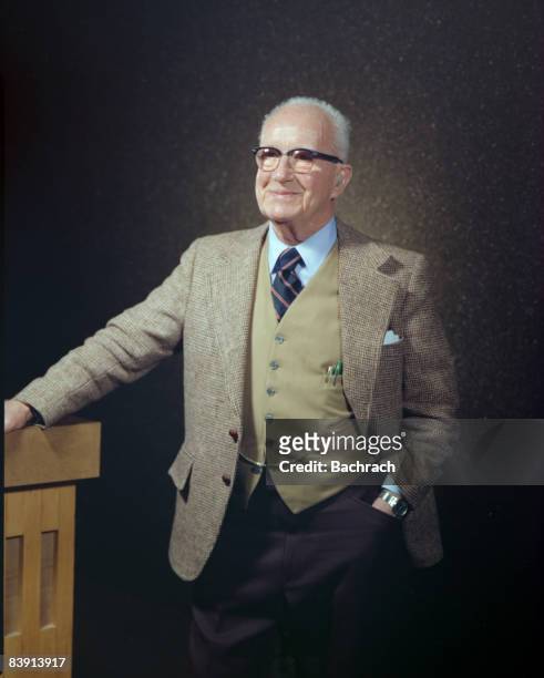 Portrait of American architect, inventor and futurist Buckminster Fuller as he sits at a table with his hand on his chin, Boston, Massachussetts,...
