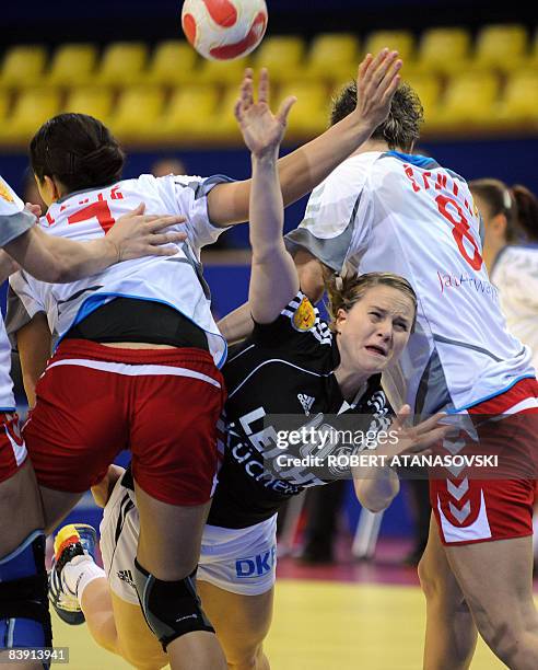 Germany' s Anna Loerper vies with Serbia's Dijana Stevin and Andrea Lekic during the 8th Women's Handball European Championships match on December 4,...