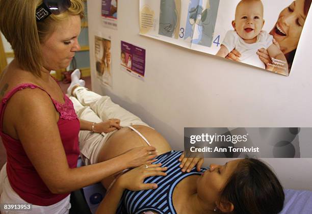 Midwife Zoe Dorgan measures a patient's belly at a midwifery clinic in Shoreditch, Hackney Borough, on July 28, 2008 in London, England. The clinic...