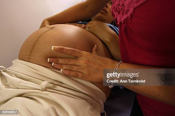 Midwife Zoe Dorgan examines a patient's belly to determine the position of the baby at a midwifery clinic in Shoreditch, Hackney Borough, on July 28,...