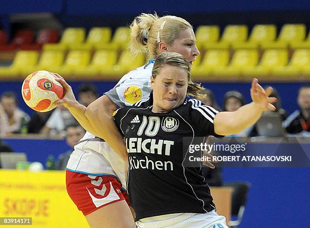 Germany's Anna Loerper fights for the ball with Serbia's Sanja Rajovic during their 8th Women's Handball European Championships match on December 4,...