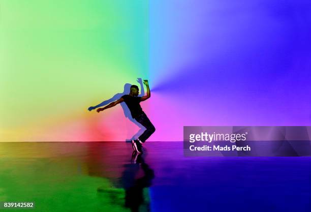 man dancing in abstract space with lots of colours around him - performance stock-fotos und bilder