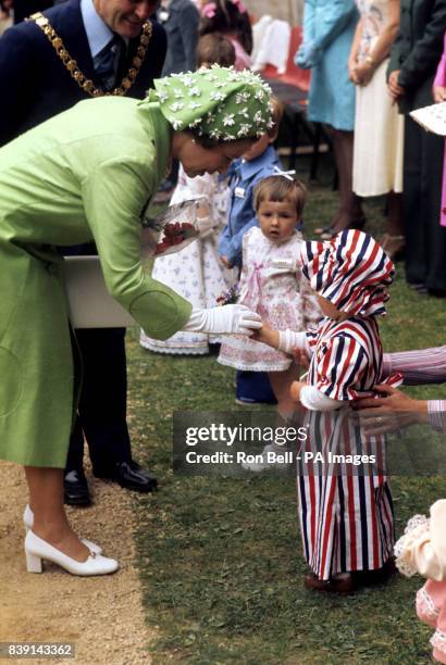 Queen Elizabeth II receives a flower from a child at Caerphilly Castle, Wales.