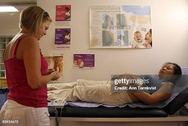 Midwife Zoe Dorgan prepares to examine the belly of a pregnant patient at a clinic in Shoreditch, Hackney Borough, on July 28, 2008 in London,...