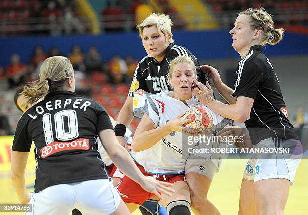 Serbia's Sanja Rajovic fights for the ball with Germany's Nina Worz and Anna Loerper during their 8th Women's Handball European Championships match...