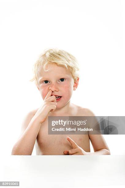 portrait of young boy with finger up his nose - mettersi le dita nel naso foto e immagini stock