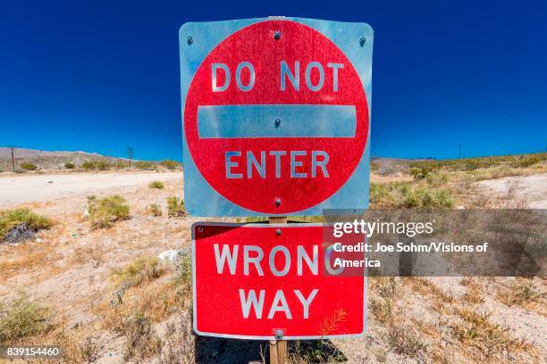 Bright Red sign warns drivers not to enter this lane of highway, Interstate 15, in desert outside of Las Vegas - WARNING - WRONG WAY!, Nevada.